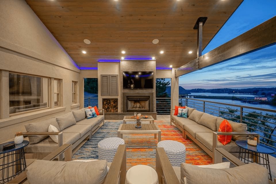 Lakeside living room with smart lighting, motorized screens and a wall-mounted TV